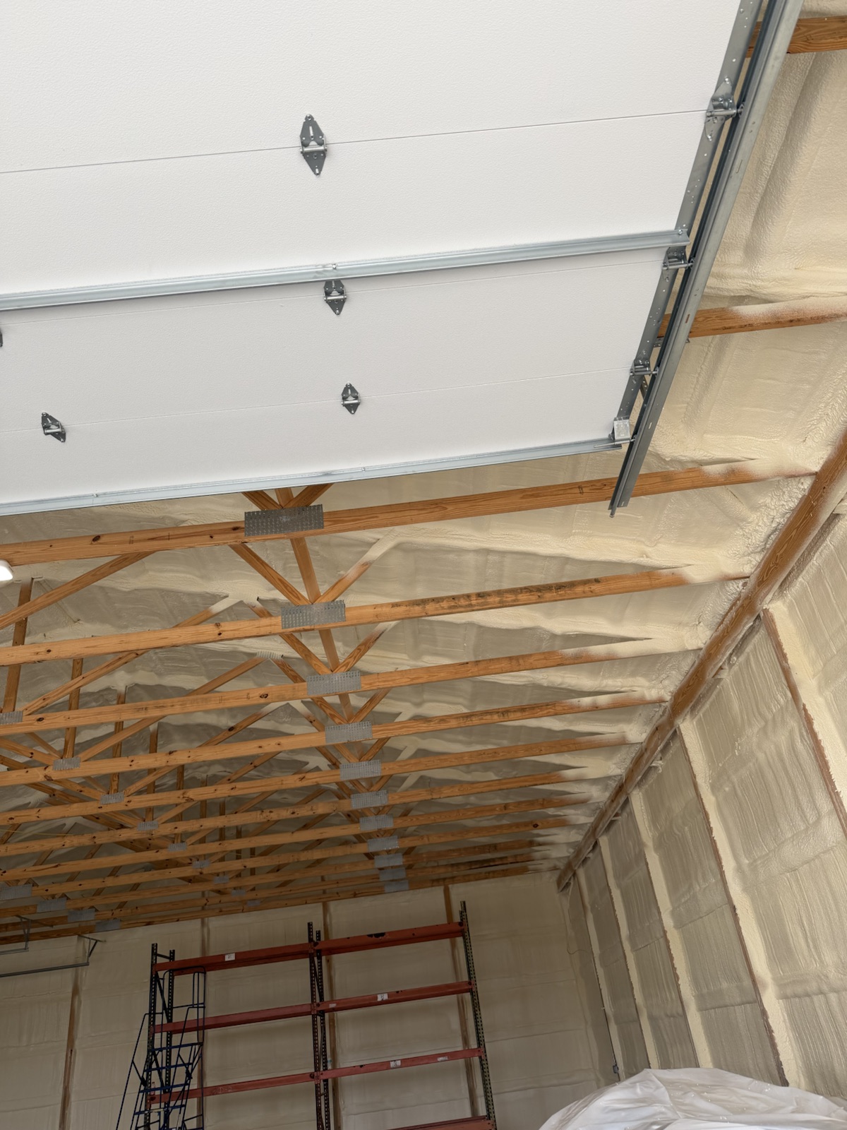 Foam across the roof above the trusses, clear of the door track.